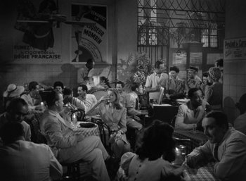 Movie still from “To Have and Have Not” (1944), directed by Howard Hawks – A black and white photo of people sitting at tables; Wide shot, High angle