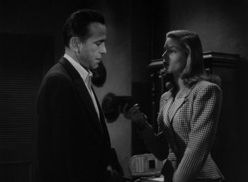 Movie still from “To Have and Have Not” (1944), directed by Howard Hawks – A black and white photo of a man and a woman talking; Medium shot, Low angle