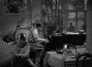 Movie still from “To Have and Have Not” (1944), directed by Howard Hawks – A group of people sitting at a table in a restaurant; Wide shot, High angle