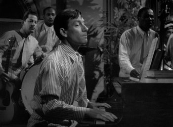 Movie still from “To Have and Have Not” (1944), directed by Howard Hawks – Black and white photograph of a man playing a piano; Medium shot, High angle