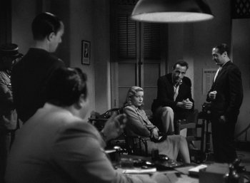 Movie still from “To Have and Have Not” (1944), directed by Howard Hawks – A black and white photo of people sitting at a table; Wide shot, Over the shoulder angle