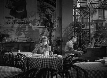 Movie still from “To Have and Have Not” (1944), directed by Howard Hawks – Two people are sitting at a table in a restaurant; Wide shot, High angle