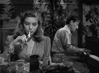 Movie still from “To Have and Have Not” (1944), directed by Howard Hawks – A man and a woman sitting at a table in a restaurant; Medium shot, Over the shoulder angle