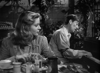 Movie still from “To Have and Have Not” (1944), directed by Howard Hawks – A man and a woman sitting at a table in a restaurant; Medium shot, Low angle