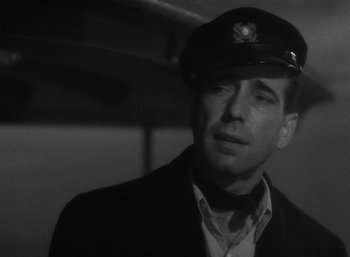 Movie still from “To Have and Have Not” (1944), directed by Howard Hawks – A man wearing a hat and a jacket; Close Up shot, Low angle