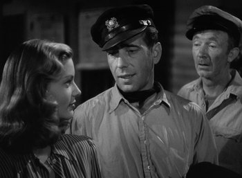 Movie still from “To Have and Have Not” (1944), directed by Howard Hawks – A black and white photo of two men and a woman; Medium shot, Over the shoulder angle