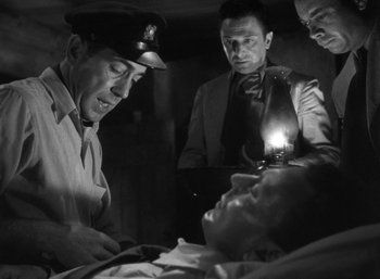 Movie still from “To Have and Have Not” (1944), directed by Howard Hawks – A group of men standing next to each other in a room; Medium shot, High angle