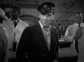 Movie still from “To Have and Have Not” (1944), directed by Howard Hawks – A black and white photo of a man wearing a hat; Medium shot, Low angle