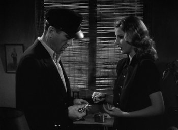 Movie still from “To Have and Have Not” (1944), directed by Howard Hawks – A man and a woman are looking at each other; Medium shot, High angle