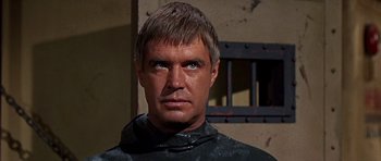 Movie still from “Tobruk” (1967), directed by Arthur Hiller – A person wearing a black shirt; Close Up shot, Over the shoulder angle