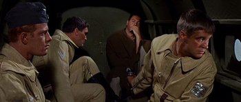 Movie still from “Tobruk” (1967), directed by Arthur Hiller – A group of men sitting on top of an airplane; Medium shot, Over the shoulder angle