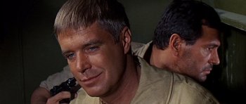 Movie still from “Tobruk” (1967), directed by Arthur Hiller – A person with a microphone in his ear; Close Up shot, Over the shoulder angle