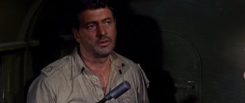 Movie still from “Tobruk” (1967), directed by Arthur Hiller – A person holding a microphone; Close Up shot, Over the shoulder angle