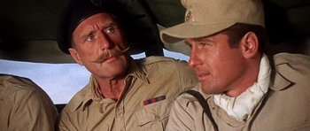 Movie still from “Tobruk” (1967), directed by Arthur Hiller – Two men are sitting next to each other; Close Up shot, Low angle