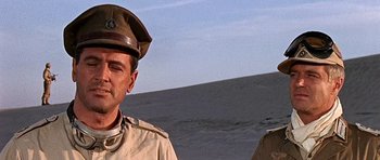 Movie still from “Tobruk” (1967), directed by Arthur Hiller – A man in a military uniform standing in front of a body of water; Close Up shot, Low angle