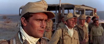 Movie still from “Tobruk” (1967), directed by Arthur Hiller – A group of men standing next to each other wearing hats; Close Up shot, Low angle