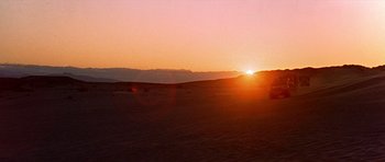Movie still from “Tobruk” (1967), directed by Arthur Hiller – The sun is setting over a desert plain; Extreme Wide shot, Low angle