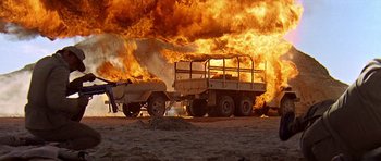Movie still from “Tobruk” (1967), directed by Arthur Hiller – A truck that is on fire in a field; Extreme Wide shot, Low angle