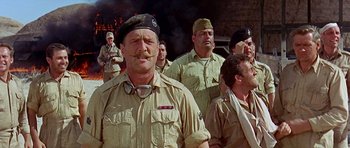 Movie still from “Tobruk” (1967), directed by Arthur Hiller – A group of men standing next to each other; Medium shot, Low angle