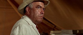 Movie still from “Tobruk” (1967), directed by Arthur Hiller – An older man wearing a hat and a white shirt; Close Up shot, Low angle