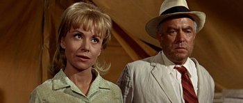 Movie still from “Tobruk” (1967), directed by Arthur Hiller – A man and a woman standing next to each other; Close Up shot, Low angle