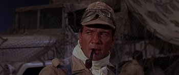Movie still from “Tobruk” (1967), directed by Arthur Hiller – A person with a pipe in his mouth; Close Up shot, Low angle