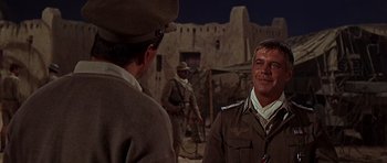 Movie still from “Tobruk” (1967), directed by Arthur Hiller – Two men in military uniforms talking to each other; Medium shot, Over the shoulder angle
