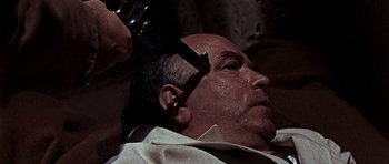 Movie still from “Tobruk” (1967), directed by Arthur Hiller – A man getting his head shaved by a barber; Close Up shot, High angle