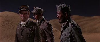 Movie still from “Tobruk” (1967), directed by Arthur Hiller – A group of men standing next to each other on top of a hill; Medium shot, Low angle