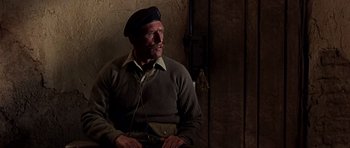 Movie still from “Tobruk” (1967), directed by Arthur Hiller – An older man wearing a beret and a sweater; Medium shot, Over the shoulder angle