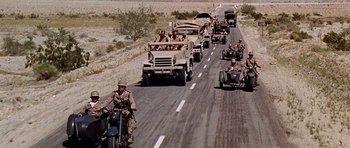 Movie still from “Tobruk” (1967), directed by Arthur Hiller – A group of military vehicles driving down a road; Wide shot, High angle