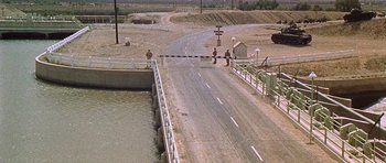 Movie still from “Tobruk” (1967), directed by Arthur Hiller – A road that has been closed off by a bridge; Extreme Wide shot, High angle