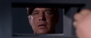 Movie still from “Tobruk” (1967), directed by Arthur Hiller – A person looking at a mirror; Close Up shot, Low angle