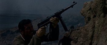 Movie still from “Tobruk” (1967), directed by Arthur Hiller – A man holding a gun up to the sky; Close Up shot, Low angle