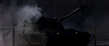 Movie still from “Tobruk” (1967), directed by Arthur Hiller – An old tank is lit up by the light of a street light; Wide shot, Low angle