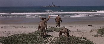 Movie still from “Tobruk” (1967), directed by Arthur Hiller – A group of men on a beach near the water; Wide shot, Low angle