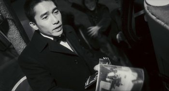 Movie still from “Happy Together” (1997), directed by Kar-Wai Wong – A black and white photo of a man in a suit and bow tie; Close Up shot, Over the shoulder angle