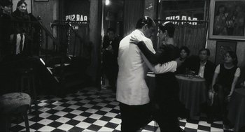 Movie still from “Happy Together” (1997), directed by Kar-Wai Wong – A man and a woman are dancing in a restaurant; Wide shot, Low angle