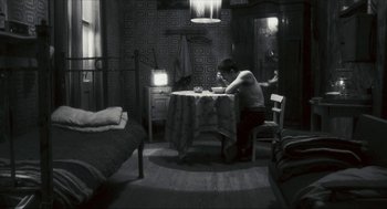 Movie still from “Happy Together” (1997), directed by Kar-Wai Wong – A man sitting at a table in a room; Wide shot, High angle