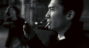 Movie still from “Happy Together” (1997), directed by Kar-Wai Wong – A black and white photo of a man smoking a cigarette; Close Up shot, Low angle
