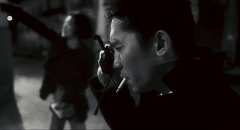 Movie still from “Happy Together” (1997), directed by Kar-Wai Wong – A man smoking a cigarette while holding a cell phone to his ear; Close Up shot, Low angle