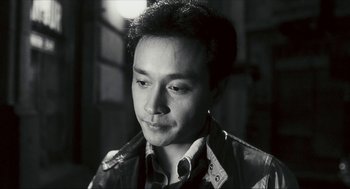 Movie still from “Happy Together” (1997), directed by Kar-Wai Wong – Black and white photograph of a man in a leather jacket; Close Up shot, Low angle