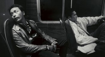 Movie still from “Happy Together” (1997), directed by Kar-Wai Wong – Two men are sitting on a bus together; Medium shot, Low angle