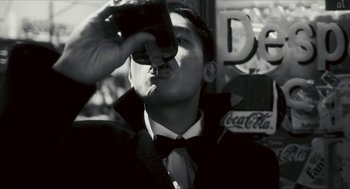 Movie still from “Happy Together” (1997), directed by Kar-Wai Wong – A man in a suit and tie drinking from a bottle; Close Up shot, Low angle