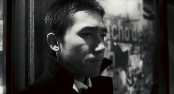 Movie still from “Happy Together” (1997), directed by Kar-Wai Wong – Black and white photograph of a young man in a suit; Close Up shot, Low angle