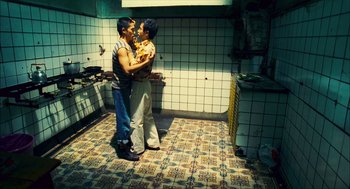 Movie still from “Happy Together” (1997), directed by Kar-Wai Wong – A couple of men standing next to each other in a kitchen; Wide shot, Overhead angle