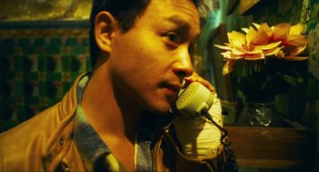 Movie still from “Happy Together” (1997), directed by Kar-Wai Wong – A man holding a phone up to his ear; Close Up shot, High angle