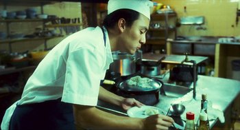 Movie still from “Happy Together” (1997), directed by Kar-Wai Wong – A man in a chef's outfit preparing food; Medium shot, Low angle