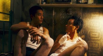 Movie still from “Happy Together” (1997), directed by Kar-Wai Wong – Two young men sitting on a couch in a living room; Medium shot, High angle