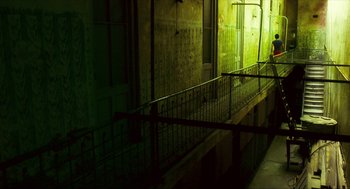 Movie still from “Happy Together” (1997), directed by Kar-Wai Wong – A dark room with a railing on the side of the building; Extreme Wide shot, Low angle